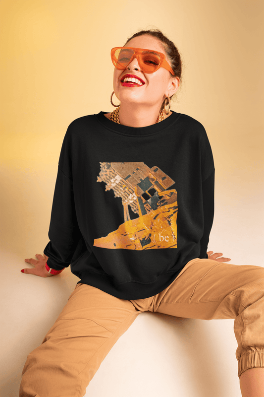 Mujer sentada vistiendo sudadera negra con gráfico industrial amarillo Mechanism.