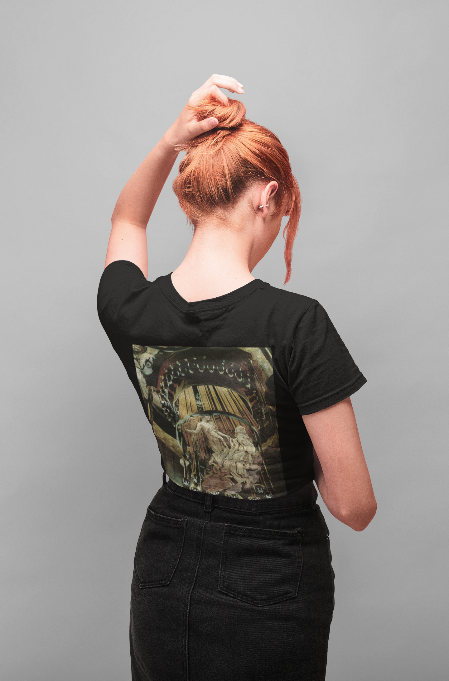 Vista trasera de chica pelirroja vistiendo camiseta negra con diseño Extasis.