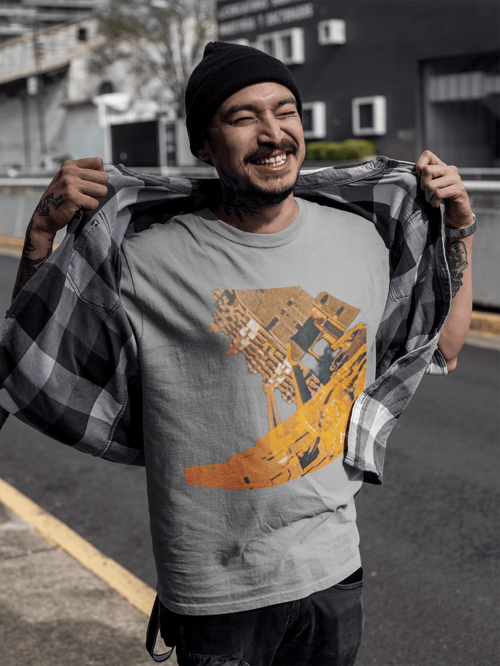 Hombre alegre vistiendo camisera gris con gráfico industrial amarillo Mechanism.
