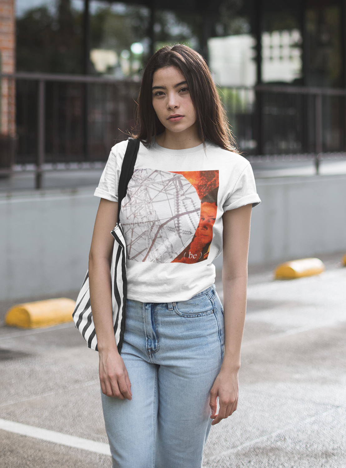 Mujer frente a edificio de ladrillo con camiseta blanca diseño Internal Mind.